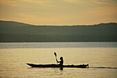 A woman kayaking on Sebago Lake.; Sebago Lake, Maine.
