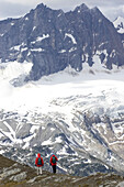 Zwei Wanderer halten inne, um die schöne Aussicht zu genießen; Adamants Mountain Range, British Columbia, Kanada