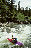 A kayaker paddles to get through the rapids.; Middle Fork of the Salmon River, Idaho