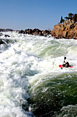 A whitewater kayaker on the verge of a big drop.; Great Falls, Potomac River, Maryland.