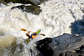 A kayaker paddles off a waterfall into big whitewater.; Great Falls, Potomac River, Virginia.