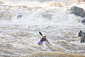Kayaker paddles through a raging rapid.; Great Falls of the Potomac River - Maryland/Virginia, USA