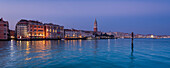 View of the City of Venice with the Campanile di San Marco, across the Grand Canal (Canal Grande) from the Punta della Dogana a la Salute in Veneto at twilight; Venice, Italy