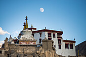 Nahaufnahme des tibetisch-buddhistischen Lamayuru-Klosters auf einer Klippe bei Sonnenuntergang in Lamayouro im Distrikt Leh in der Region Ladakh, mit dem Mond am blauen Himmel; Jammu und Kaschmir, Indien