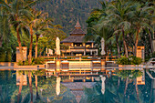 Blick auf die Spiegelung eines Luxushotels im Swimmingpool bei Sonnenuntergang; Koh Lanta, Provinz Krabi, Thailand