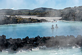 Menschen genießen die Blaue Lagune, eine künstlich angelegte Lagune mit heißen Quellen in der Nähe von Reykjavik und eine beliebte Touristenattraktion; Reykjavik, Südwestisland, Island