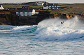 Person genießt den Wellenschlag in der Constantine Bay bei Padstow; Constantine Bay, Cornwall, England, Großbritannien