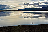 Expedition team member leaves his trusty boat behind him and the expanse of lake Centrum to take  a walk up to the limestone cliffs after another team member who had spotted a cave.