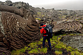 A cave explorer photographs the swirls and shapes of hardened molten lava.