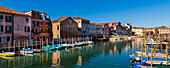 Bunte Gebäude und angedockte Boote am Ufer des Canale de San Pietro im Castello-Viertel von Venedig; Venetien, Venedig, Italien