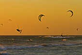 Kite surfers at sunset.