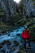 Blick von hinten auf eine Frau, die die Schluchten und die Landschaft von Thorsmork erkundet, einem Gebiet von außergewöhnlicher Schönheit in Südisland; Thorsmork, Südküste, Island