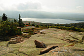 Scenic view of a distant lake from a rocky slope of Cadillac Mountain.; Acadia National Park, Mount Desert Island, Maine.