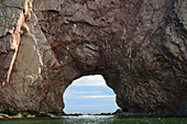 Close view of the window, or natural arch, in Perce Rock.; Ile Bonaventure et du Rocher-Perce National Park, Perce, Gaspe Peninsula, Quebec, Canada.