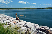 Eine Bronzeskulptur eines Fischers auf den Felsen am Point Bonaventure; Point Bonaventure, Bonaventure, Quebec, Kanada.