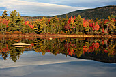 Scenic view of trees and hills reflected in the still water of a pond in autumn.; Bartlett, New Hampshire, USA.