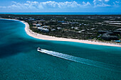Luftaufnahme eines Bootes, das an einer Insel vorbeisegelt; Turks- und Caicosinseln, Westindische Inseln