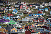 Nahaufnahme der farbenfrohen Gebäude an den felsigen Klippen entlang der Küste in der Hafenstadt Qaqortoq an der Südspitze Grönlands; Qaqortoq, Südgrönland, Grönland