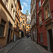 Fußgänger gehen eine schmale Straße zwischen Gebäuden entlang; Stockholm Schweden