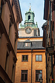 Clock Tower On A Church Rising Above The Rooftops In Old Town; Stockholm Sweden