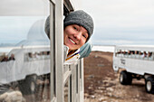 A Young Woman Looks Out The Window Of A Tundra Vehicle On A Polar Bear Expedition; Churchill Manitoba Canada