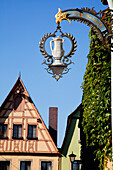Eine silberne Kaffeekanne auf einem hängenden Schild gegen einen blauen Himmel; Rothenburg Ob Der Tauber Bayern Deutschland