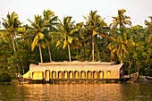 A Boat Sitting At The Shoreline With Palm Trees; Kerela India