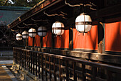 Japanische Tempellaternen und rote Wand; Kyoto, Japan