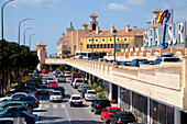 Verkehr und geparkte Autos auf einer belebten Straße; Bahia Sur, San Fernando, Andalusien, Spanien