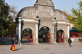 Pedestrians By An Arched Gate; Beijing China