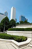 Buildings Against A Blue Sky And A Landscaped Area With Shrubs Trees And Railings; Chicago Illinois United States Of America