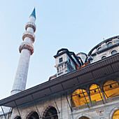 Niedriger Blickwinkel eines hohen Turms der Moschee des Valide Sultan vor blauem Himmel; Istanbul Türkei