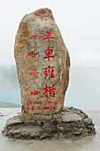 China, Xizang, Felsen mit roten chinesischen Schriftzeichen