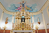 Colorful religious depiction painted on ceiling of church with gold accents and candles at alter; Louisiana, New Orleans, USA