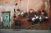 Dekorative Kugeln und Wandkunst aus Metall auf einer alten Mauer; Medina, Marrakesch, Marokko