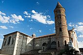 Italy, Emilia-Romagna, Ravenna, Basilica Di San Vitale, Brick round tower and stone church against sky with clouds