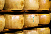 Italy, Emilia-Romagna, Bologna, Close up of Reggiano Parmigiano cheese wheels on shelves