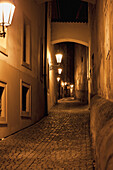 Czech Republic, Alley illuminated by lights at night; Prague