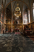 Czech Republic, large arched windows and chandelier; Prague, Interior of church with colorful depictions painted on walls
