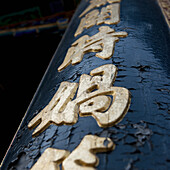 Ein Schild an einem Pfosten mit abblätternder Farbe; Peking, China