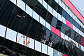 Modernes Gebäude mit Spiegelungen in den Glaswänden; Peking, China