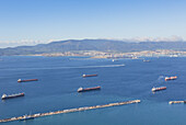 Blick über die Bucht von Gibraltar, auch bekannt als Bucht von Algeciras, nach Algeciras in Spanien mit Frachtschiffen vor Anker in gibraltarischen Gewässern und der Fähre von Ceuta nach Algeciras hinter den Frachtschiffen; Gibraltar