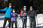 Two Couples Cross Country Skiiing On A Tracked Trail; Lake Louise, Alberta, Canada