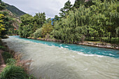 Zwei zusammenfließende Flüsse mit unterschiedlich gefärbtem Wasser in der Nähe des Eingangs zum Jiuzhaigou Valley National Park; Jiuzhaigou, Sichuan, China