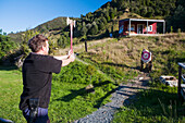 A Man Takes An Attempt At An Axe Throw At Blue Duck Lodge, In Whanganui National Park; Whakahoro, New Zealand