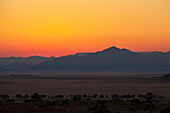 Sonnenaufgang mit einer Silhouette der Landschaft; Namibia