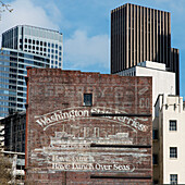 Kontrast von alten und modernen Gebäuden mit einer gemalten Werbung für Washington State Ferries; Seattle, Washington, Vereinigte Staaten Von Amerika