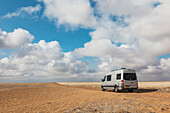 A Camper Van Is Parked In An Oklahoma Panhandle Wheat Field With Dramatic White Clouds And Blue Sky Near Highway 56 Northeast Of Boise City; Oklahoma, United States Of America