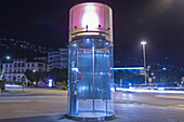 Eine runde, nachts beleuchtete Telefonzelle; Locarno, Tessin, Schweiz