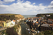 Boats In The River And Rooftops; Staithes, North Yorkshire, England